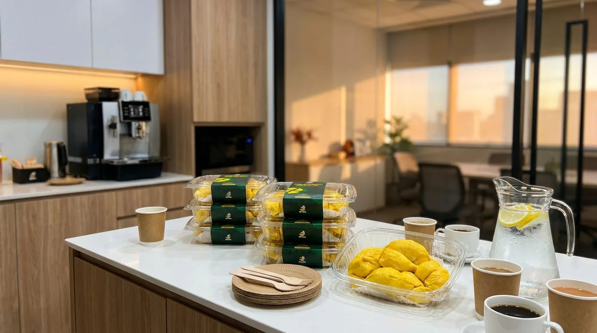 Boxes of Spike Durian Mao Shan Wang and an open tray of durian on an office pantry counter with coffee and plates